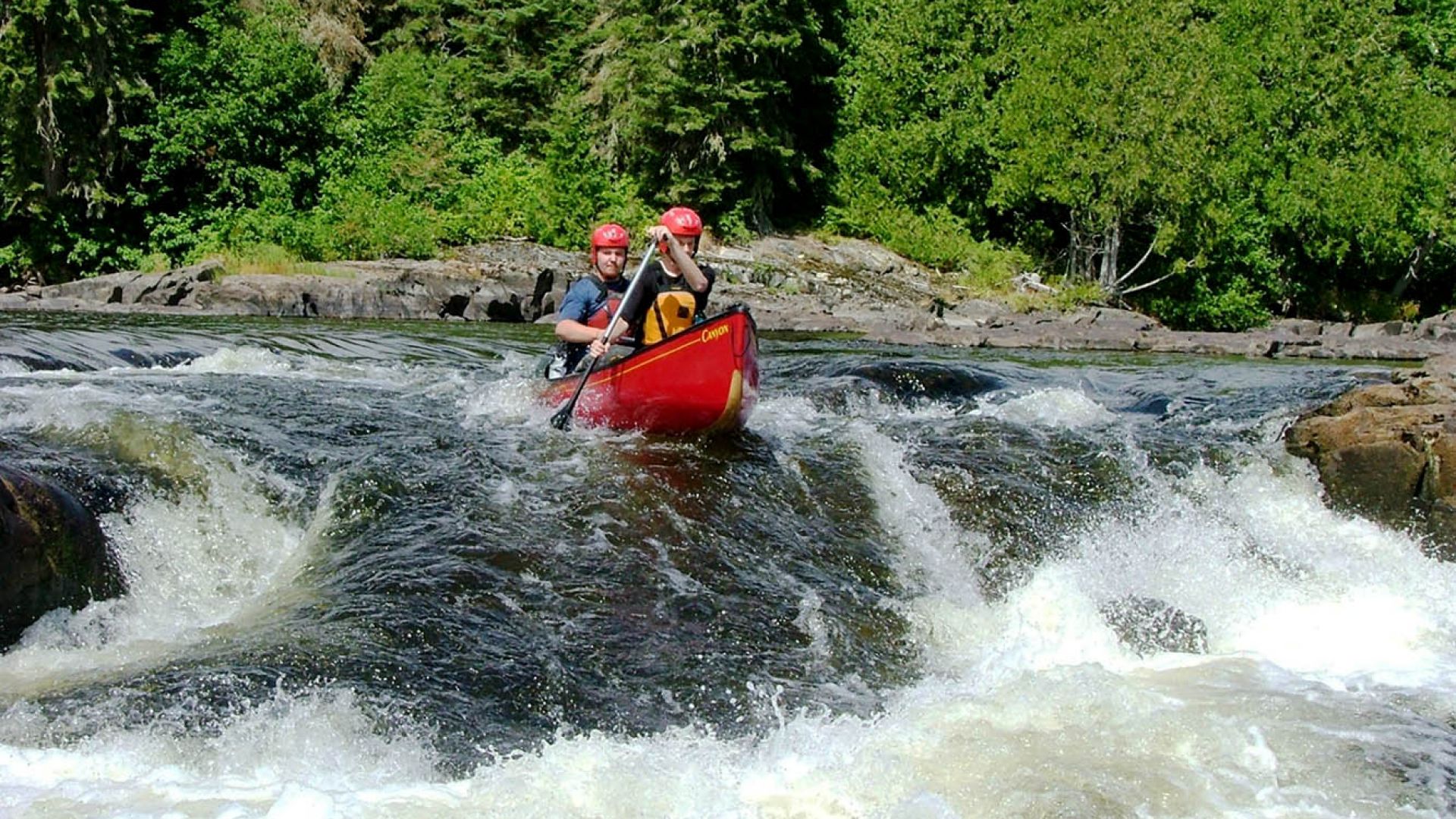 Two paddlers canoe a set of rapids on the Missinaibi River