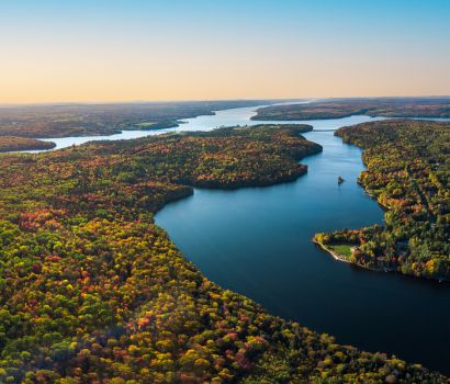 Wolastoq/St. John River flowing through colourful deciduous forests in the fall. // Fleuve Wolastoq/Saint-Jean coulant à travers des forêts de feuillus colorées en automne.