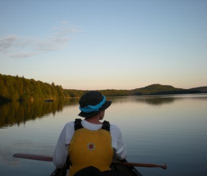 Un canotier regarde au-delà de l'horizon des eaux calmes et tranquilles de la rivière Mattawa.