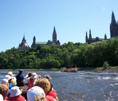 Un groupe de pagayeurs fait la fête sur la rivière des Outaouais, devant la colline du Parlement.