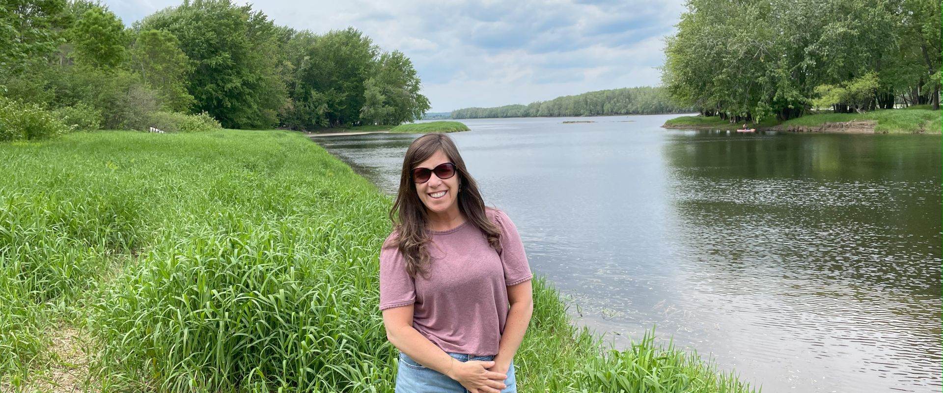 Molly Demma standing in front of a river. // Molly Demma debout devant une rivière.